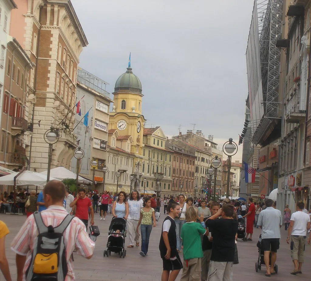 Visitors on a pedestrian street lined with old buildings in Rijeka