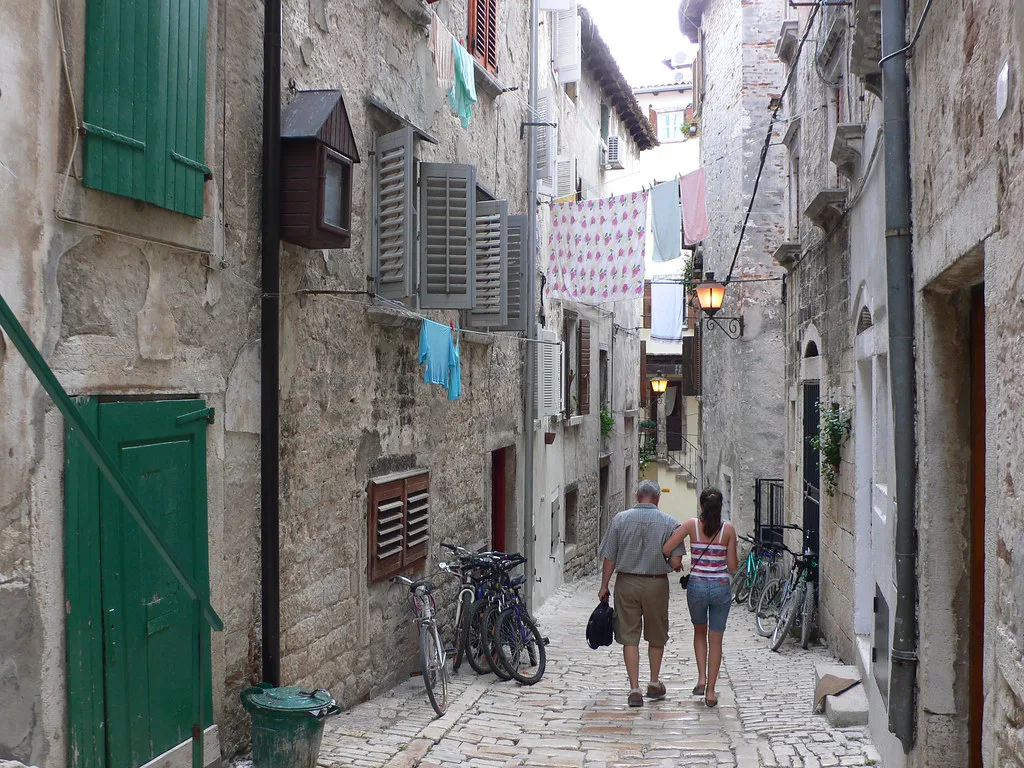 Visitors walking along a narrow stone lane in the old town of Rovinj