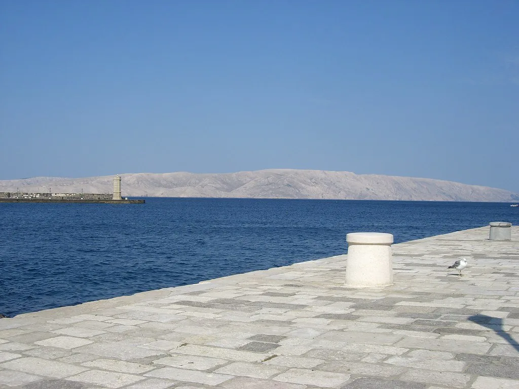 A stone pier on the waterfront in Senj looking across the sea.