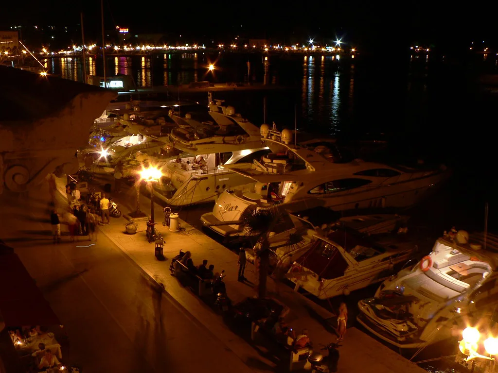 Boats moored beside the lit Poreč waterfront at night