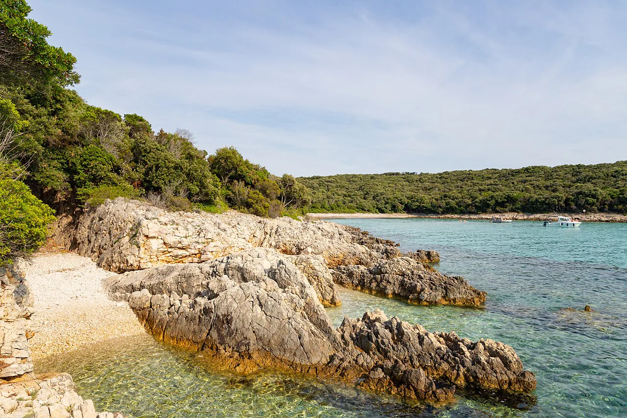 Rocky shoreline and clear water in a small bay on Silba.