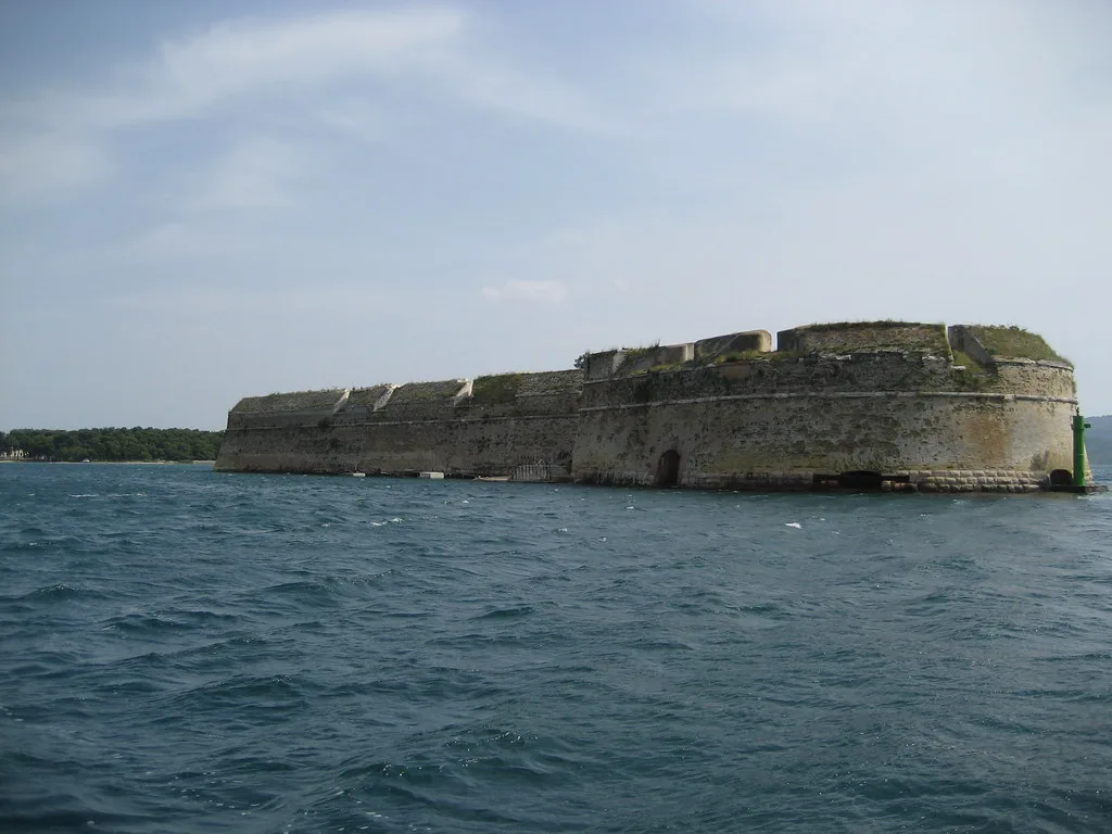 The low stone walls of St Nicholas Fortress rising from the sea near Šibenik