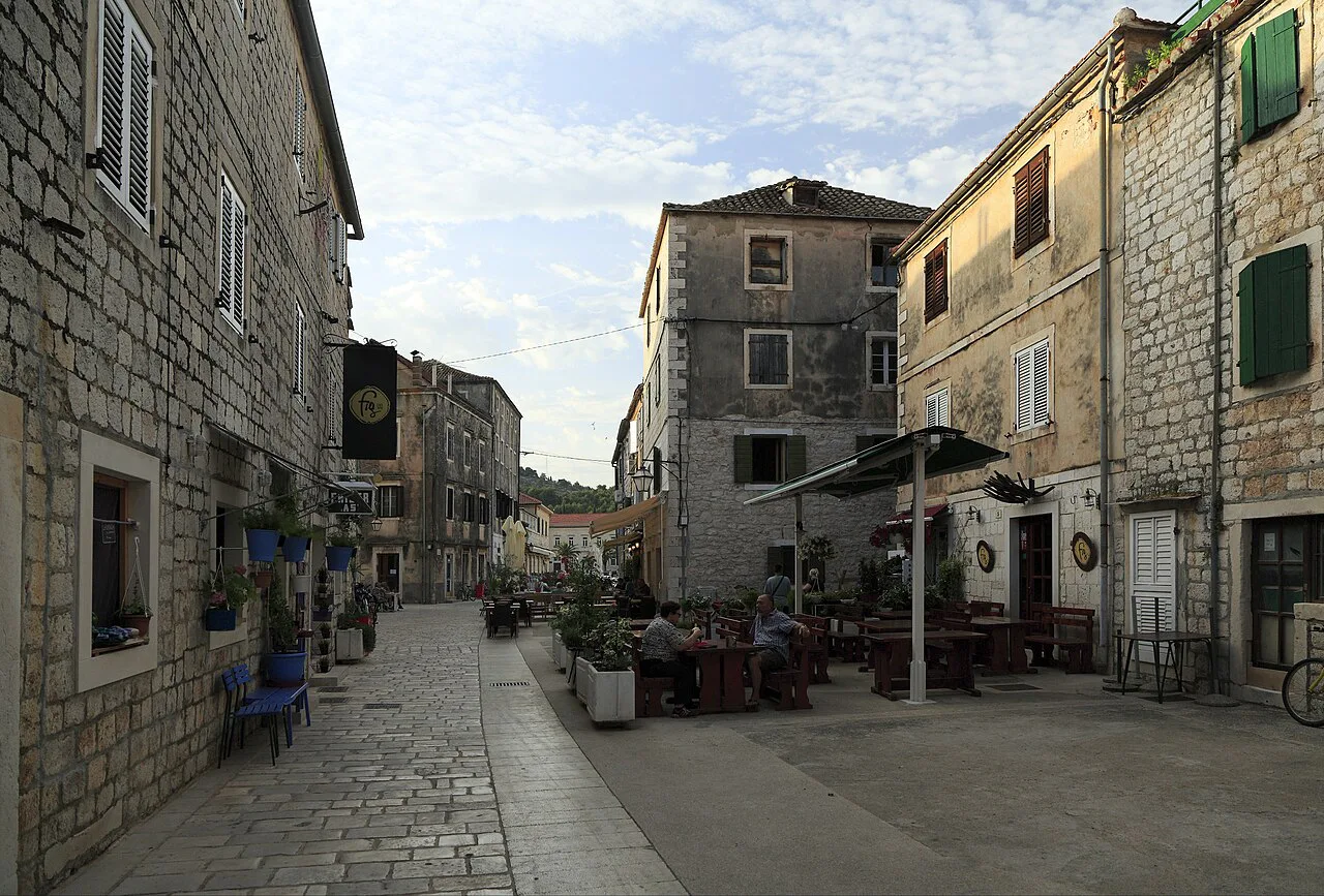 Café tables along a narrow stone street in Stari Grad, Hvar