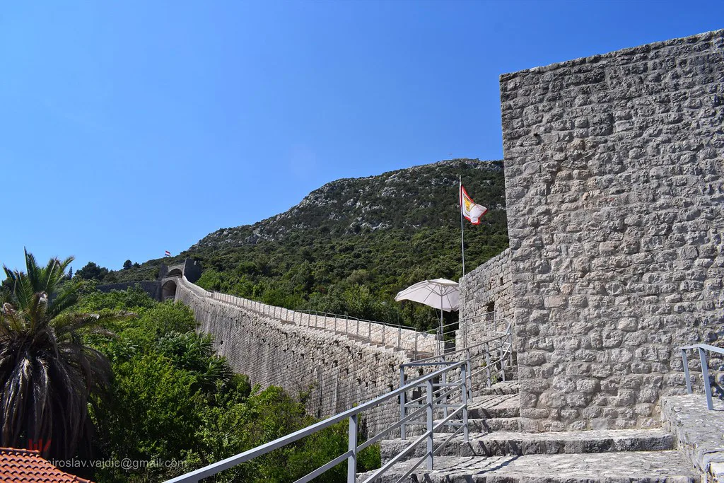 The defensive walls of Ston climbing a green hillside, Southern Dalmatia