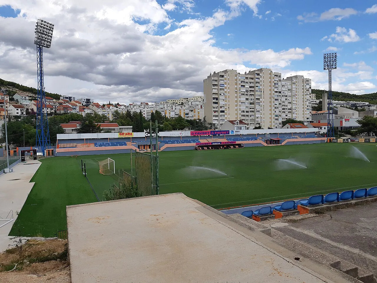 Šubićevac stadium with residential blocks and hillside houses behind it in Šibenik