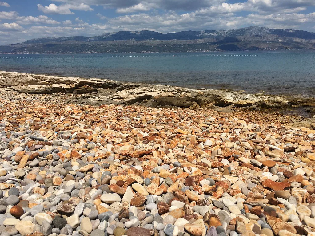 A colourful pebble beach in Supetar on the island of Brač