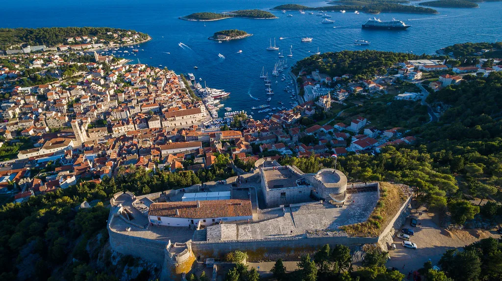 An aerial view of Hvar Town, its harbour and the fortress above.