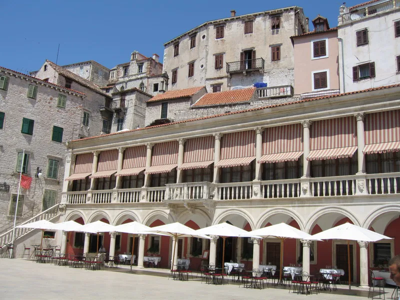 The arcaded town hall with café tables on its terrace in Šibenik