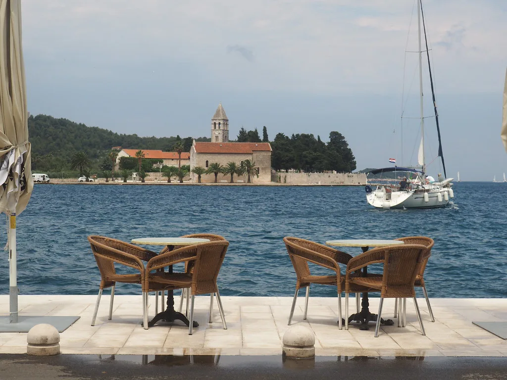Café tables on the seafront looking across the harbour on the island of Vis